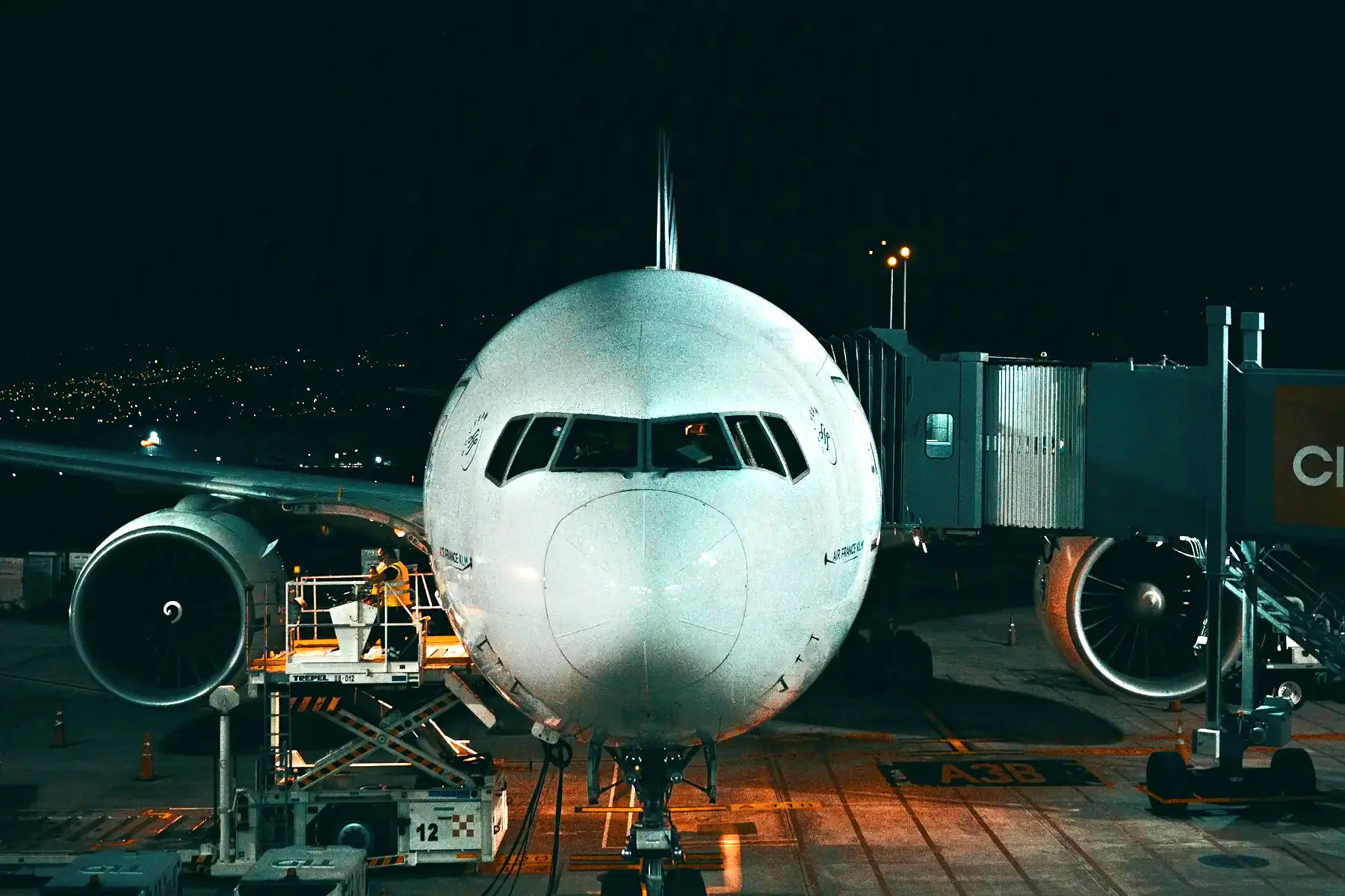 A passenger plane at an airport gate in Costa Rica at night