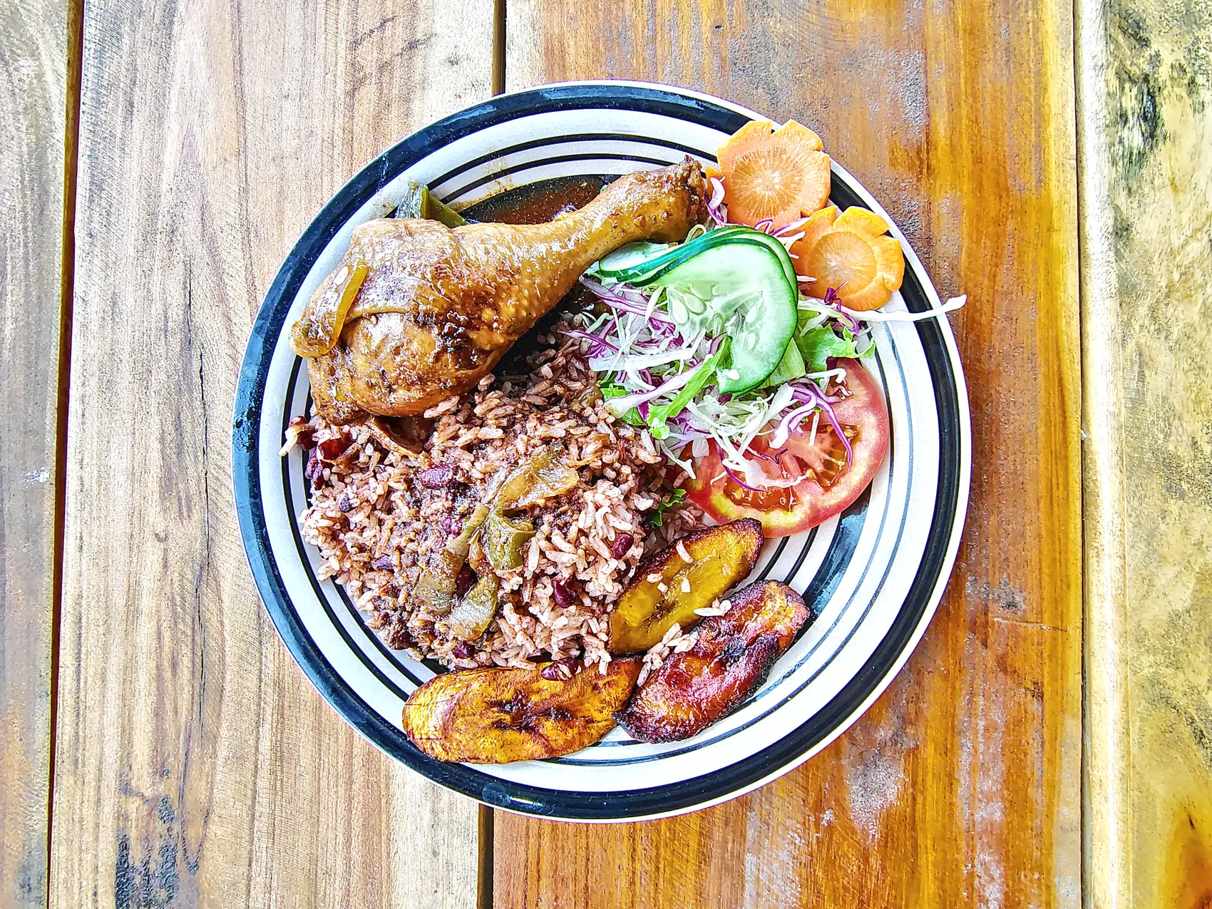 A plate of chicken, rice and beans, plantain and salad at Cahuita