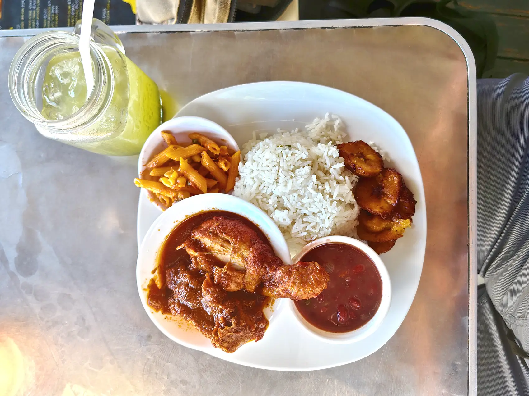Chicken, beans, rice and fried plantain with a jar of lemonade in Puerto Viejo