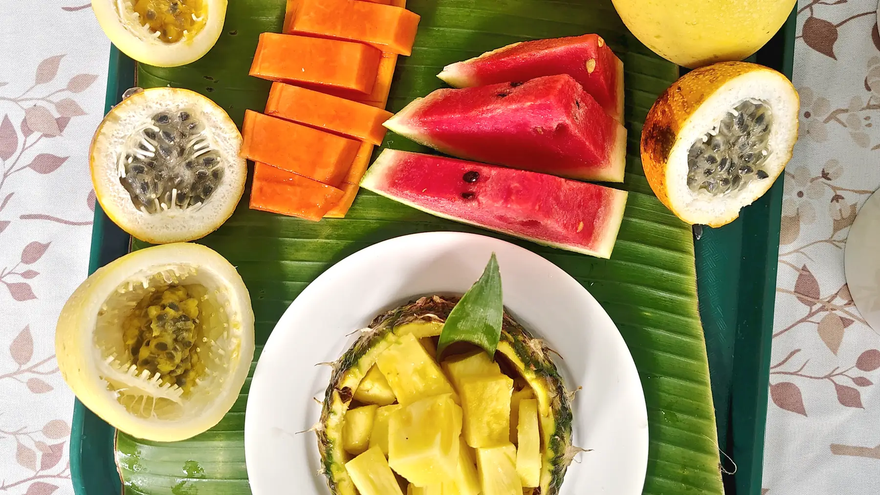 A platter of tropical fruit on a banana leaf