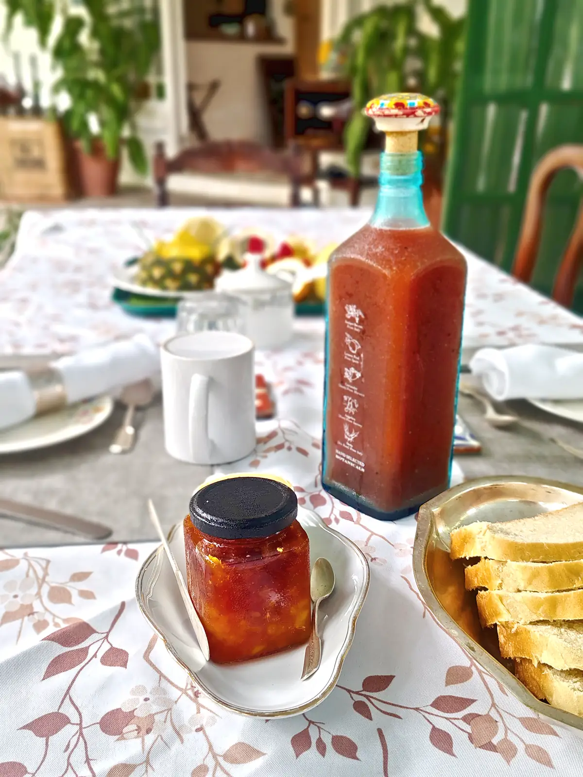 Homemade hot sauce and preserves on a breakfast table