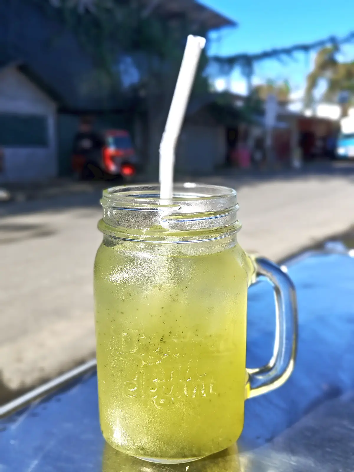 A jar of lemonade with a straw on a table in Puerto Viejo