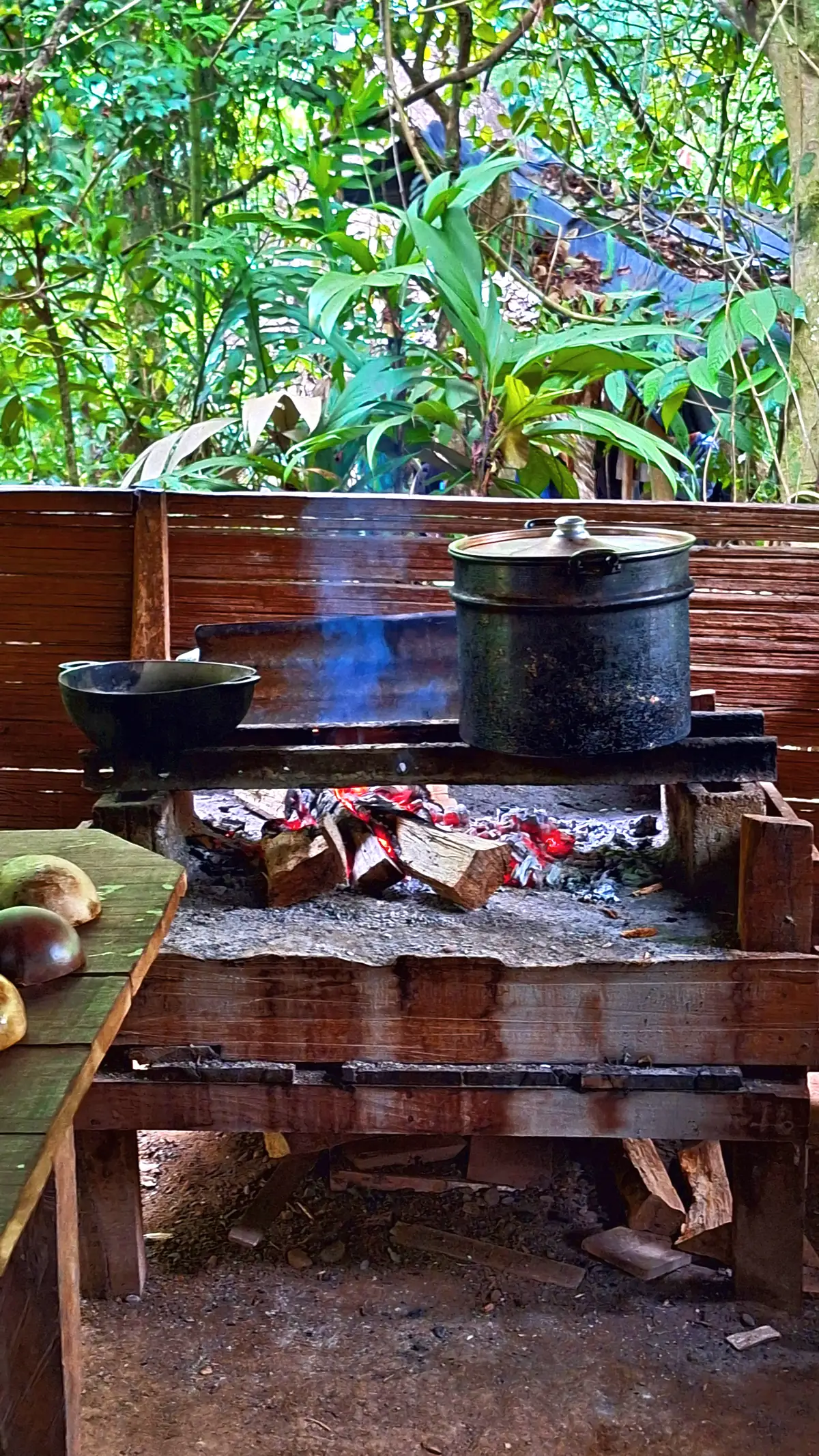 A wood-fired outdoor kitchen with a blackened pot