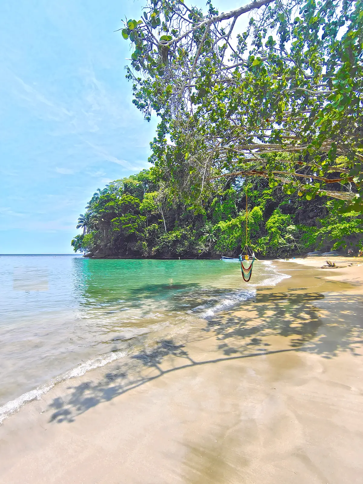 Shadows of the trees across the sand of the cove at Punta Uva