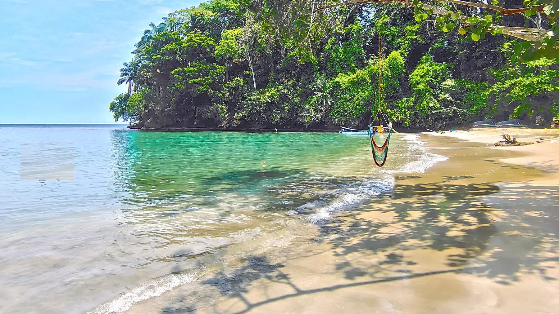 Shadows of the trees across the sand of the cove at Punta Uva