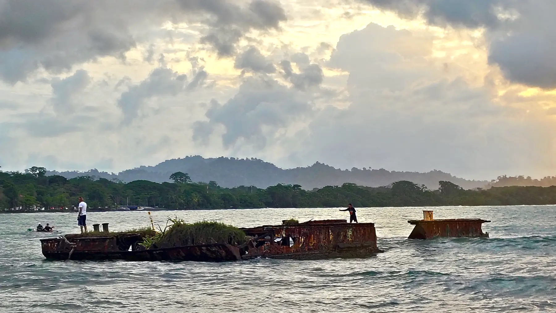 A rusted wreck and heavy clouds off the beach at Puerto Viejo